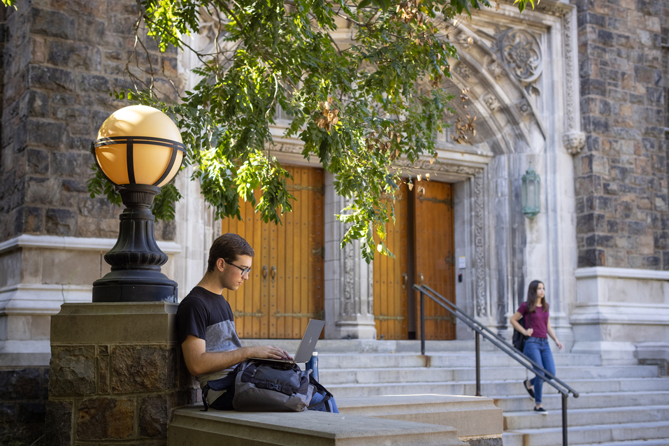 Student using a laptop outside Linderman Library at Lehigh University.